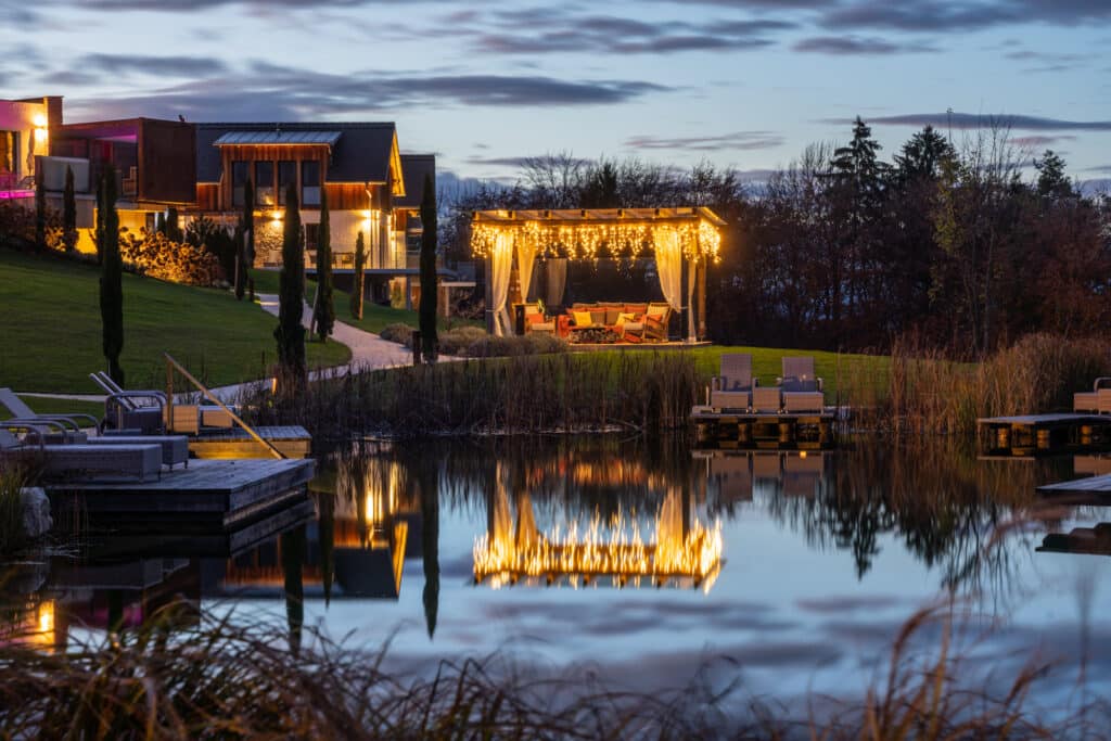 Golden Hill – Abendszene am See mit beleuchteten Chalets